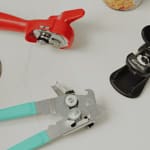 Can Openers tools laid out on a white countertop, including manual crank, butterfly-style, and ergonomic handle designs.