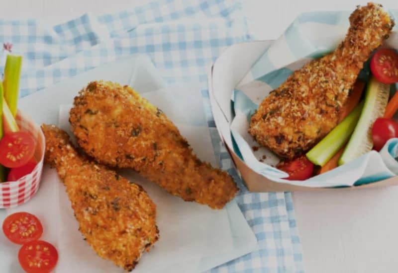 Fried Chicken served with fresh vegetables on a blue checkered cloth